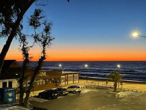 a parking lot next to the ocean at sunset at Apartamento frente al mar con vistas al Océano Atlántico in Isla Cristina