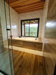 a large bathroom with a window and a tub at Araucária Guest House - Cabanas in Bocaina de Minas +16 photos