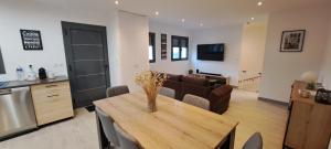 a kitchen and living room with a table and a couch at Pacific Green-80M2-Clime-2 big Suites-Parking privé 2 cars-Jardin-Confort in Chalifert +19 photos