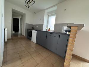 a kitchen with white appliances and a tile floor at Charmante maison en pierre in Saint-Eutrope