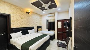 a hotel room with a bed and a tv at Hotel YO94 in Indore +23 photos