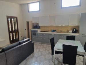 a kitchen with a table and a couch and a table and chairs at IL GELSO LECCE Affitti Brevi in Lecce