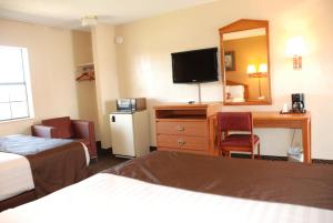 een hotelkamer met een bed, een bureau en een spiegel bij Apple Tree Inn in Lindale