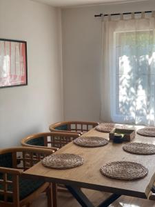 a wooden table with chairs around it with a window at Къща за гости Клонката in Dŭlbok Dol +15 photos