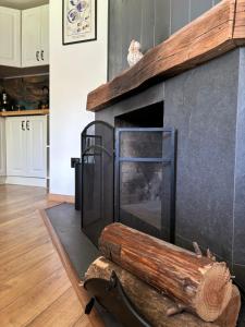 a fireplace in a living room with a wooden mantel at Къща за гости Клонката in Dŭlbok Dol