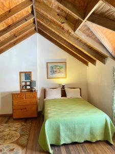a bedroom with a green bed and wooden ceilings at Bananaquit Tobago -Stay Near the Beach in Crown Point