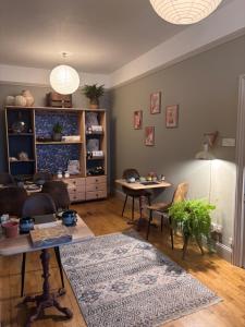 a living room with a table and a rug at Bonjour Guest house in Alderney