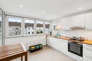 a white kitchen with white cabinets and windows at Geschäftsreisetraum 3SZ 5P - SmartTV in Oberkochen