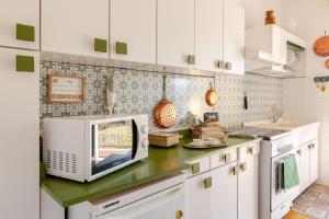 a kitchen with white cabinets and a microwave on a counter at CasaPiergiulia - Canzo - Lago di Como -Parcheggio - Wifi in Canzo