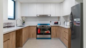 a kitchen with a stove and a refrigerator at Luxury Villa In Yas in Abu Dhabi