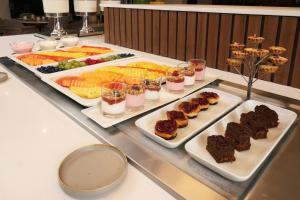a buffet with three trays of food on a table at voco Hermosillo by IHG in Hermosillo