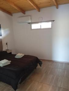 a bedroom with a black bed and a window at Vistas de Victoria in Potrero de los Funes