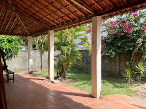 an outdoor patio with a wooden pergola at Casa do Billy in Pipa +1 photo