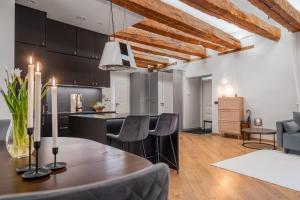 タリンにあるModern charm in old townの木製のテーブルと椅子のあるキッチンとリビングルーム
