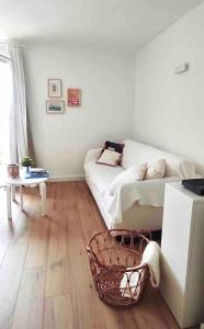 a living room with a white couch and a table at Quartier de la plage in Roquebrune-Cap-Martin