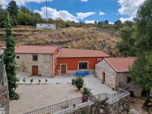 an aerial view of a stone house with red at Moinhos da Pereira - Turismo Rural in Tarouca