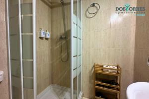 a bathroom with a shower with a glass door at Dos Torres Pilar Suites- balcones con vistas a la ciudad in Zaragoza +30 photos