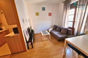 a living room with a couch and a table at Dos Torres Pilar Suites- balcones con vistas a la ciudad in Zaragoza