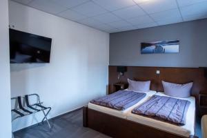 a bedroom with a bed and a flat screen tv at Hotel Restaurant Fritz in Gronau
