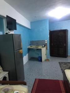 een keuken met een koelkast en een bureau in een kamer bij Dodo home in Dahab