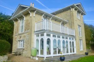 a large brick house with a balcony on it at Woodlands in Ventnor