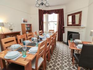 Un comedor con una mesa larga y sillas. en 50 West Street Edelweiss, en Scarborough