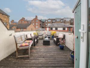 Una terraza con sillas y mesas en un balcón. en 50 West Street Edelweiss, en Scarborough