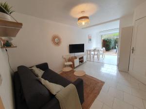 a living room with a couch and a television at T3 Jardin Piscine Plage Clim et Parking in Six-Fours-les-Plages