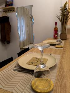 a table with two plates and a wine glass on it at Frasolis Studio Apartman in Szeged