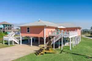 a large house with a porch and a deck at A Lil' Tipsea home in Crystal Beach