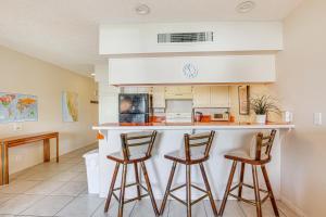 a kitchen with two bar stools and a counter at 3 Mi to Dtwn Palm Springs Condo with Pool Access! in Palm Springs