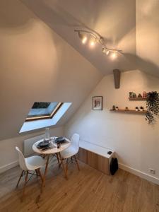 een kamer met een tafel, stoelen en een raam bij La Planque des Halles - Hyper Centre - Bureau in Troyes