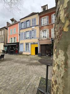 een lege binnenplaats met een boom en gebouwen bij La Planque des Halles - Hyper Centre - Bureau in Troyes