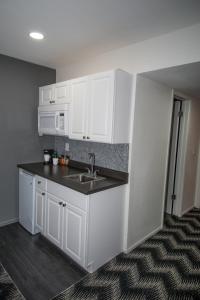 a kitchen with white cabinets and a sink at Siegel Select LV Strip-Convention Center in Las Vegas
