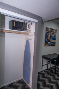 a room with a door with a microwave and a surfboard at Siegel Select LV Strip-Convention Center in Las Vegas