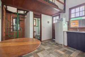 a kitchen with a wooden table and a refrigerator at Buzios Casa #6 in Búzios