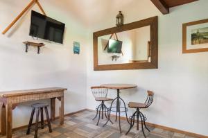 a room with a table and stools and a mirror at Buzios Casa #6 in Búzios