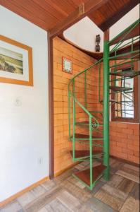 a green spiral staircase in a room with a wall at Buzios Casa #6 in Búzios