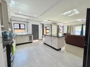 ヴィクトリア・フォールズにあるPlatinum Luxury Apartment 996の白いキャビネットと家電製品を備えた広いキッチン +23枚の写真