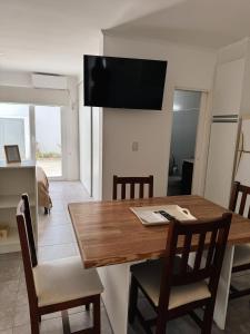 a dining room with a wooden table and chairs at Departamento Balcarce en Olavarría in Olavarría