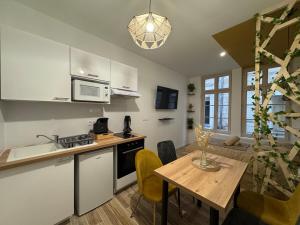 a kitchen and dining room with a table and a kitchen and a dining room at Studio hyper centre le Cosy in Niort