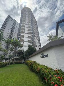 a tall building in front of a park with flowers at COP 30 - Apartamento Amplo in Belém +15 photos