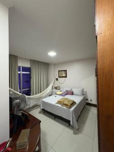 a bedroom with a bed and a desk and a lamp at COP 30 - Apartamento Amplo in Belém