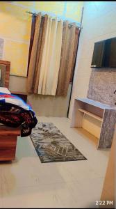 a bedroom with a bed and a table and a window at Unnati Guest House in Vrindāvan