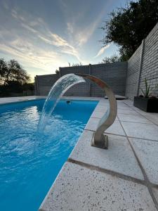 a pool with a water fountain in the middle at Villa Los Cóndores in Las Chacras
