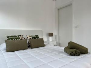 a large white bed in a white bedroom at Quinta das Pedreiras Lux in Pico da Pedra