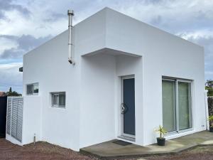 a white house with a cross on top of it at Quinta das Pedreiras Lux in Pico da Pedra