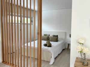 a bedroom with a bed with white sheets and pillows at Quinta das Pedreiras Lux in Pico da Pedra +3 photos