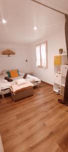 a bedroom with two beds and a wooden floor at Colibri in Val-des-Prés