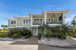 una casa con delle palme davanti di Beach Life! Two Heated Pools, Sleeps 19 - FMB - Sweet Summer - Roelens a Fort Myers Beach